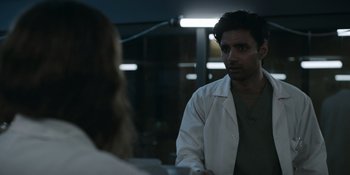 Movie still from “Awake” (2021), directed by Mark Raso – A man in a lab coat talking to a woman in a lab coat; Medium shot, Over the shoulder angle