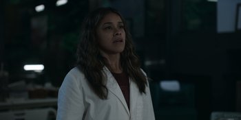 Movie still from “Awake” (2021), directed by Mark Raso – A woman wearing a lab coat standing in the dark; Close Up shot, Low angle