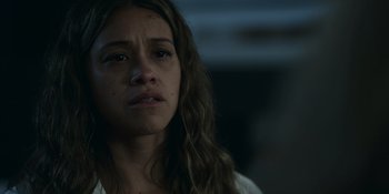 Movie still from “Awake” (2021), directed by Mark Raso – A woman with long brown hair is looking at the camera; Close Up shot, Low angle