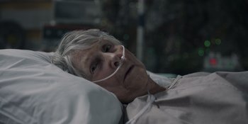 Movie still from “Awake” (2021), directed by Mark Raso – An older woman laying in a hospital bed; Close Up shot, High angle