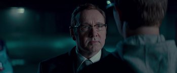 Movie still from “Baby Driver” (2017), directed by Edgar Wright – A man in a suit and tie looking at the camera; Close Up shot, Over the shoulder angle