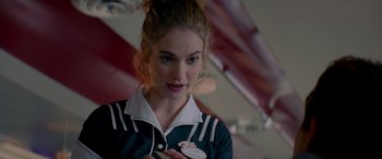 Movie still from “Baby Driver” (2017), directed by Edgar Wright – A woman in a black and white shirt holding a phone; Close Up shot, Over the shoulder angle