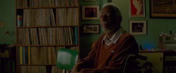 Movie still from “Baby Driver” (2017), directed by Edgar Wright – An older man sitting in a chair in front of a book shelf; Close Up shot, Over the shoulder angle
