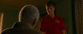 Movie still from “Baby Driver” (2017), directed by Edgar Wright – A man in a red shirt is talking to an older man; Medium shot, Over the shoulder angle
