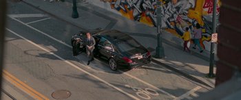 Movie still from “Baby Driver” (2017), directed by Edgar Wright – A man standing next to a car on the side of the road; Extreme Wide shot, Overhead angle