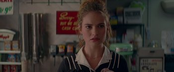 Movie still from “Baby Driver” (2017), directed by Edgar Wright – A woman standing in front of a sign in a store; Close Up shot, Over the shoulder angle