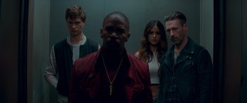 Movie still from “Baby Driver” (2017), directed by Edgar Wright – A group of men standing next to each other; Medium shot, Low angle