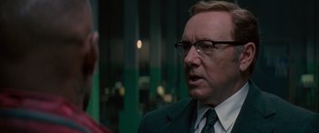 Movie still from “Baby Driver” (2017), directed by Edgar Wright – A man in a suit and tie talking to another man in a suit; Close Up shot, Over the shoulder angle