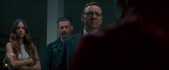 Movie still from “Baby Driver” (2017), directed by Edgar Wright – A man in a suit and tie standing next to another man in a suit and tie; Close Up shot, Over the shoulder angle