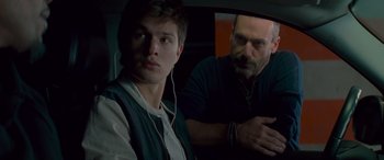 Movie still from “Baby Driver” (2017), directed by Edgar Wright – A man sitting next to another man in the back of a car; Close Up shot, Over the shoulder angle