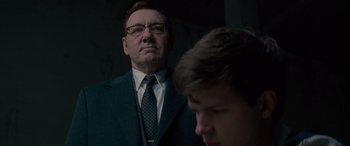 Movie still from “Baby Driver” (2017), directed by Edgar Wright – A man in a suit and tie standing next to another man in a suit and tie; Close Up shot, Low angle