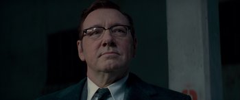 Movie still from “Baby Driver” (2017), directed by Edgar Wright – A man in a suit and tie looking to his left; Close Up shot, Low angle