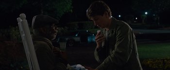 Movie still from “Baby Driver” (2017), directed by Edgar Wright – A young man sitting next to an older man outside; Medium shot, Over the shoulder angle