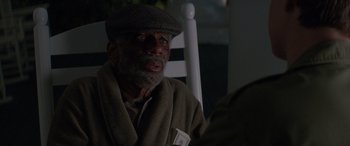 Movie still from “Baby Driver” (2017), directed by Edgar Wright – An older man sitting in a chair wearing a hat; Close Up shot, Over the shoulder angle