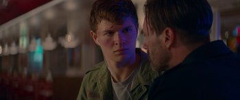 Movie still from “Baby Driver” (2017), directed by Edgar Wright – A man with headphones is talking to another man; Close Up shot, Over the shoulder angle