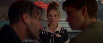 Movie still from “Baby Driver” (2017), directed by Edgar Wright – A woman in a black and white outfit standing in front of two other people; Close Up shot, Over the shoulder angle