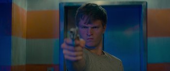 Movie still from “Baby Driver” (2017), directed by Edgar Wright – A young man holding a gun in a room; Close Up shot, Low angle
