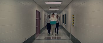 Movie still from “Baby Driver” (2017), directed by Edgar Wright – A man is walking down a hallway with two other men; Wide shot, Low angle