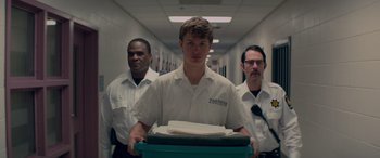 Movie still from “Baby Driver” (2017), directed by Edgar Wright – A group of men standing next to each other in a hallway; Medium shot, Low angle