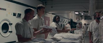 Movie still from “Baby Driver” (2017), directed by Edgar Wright – A group of men standing next to each other in a room; Medium shot, Low angle