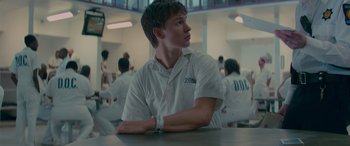 Movie still from “Baby Driver” (2017), directed by Edgar Wright – A man sitting at a table in a room; Close Up shot, Over the shoulder angle