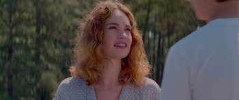 Movie still from “Baby Driver” (2017), directed by Edgar Wright – A beautiful young woman with long red hair and wearing a polka dot shirt; Close Up shot, Low angle