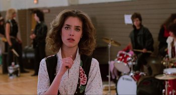 Movie still from “Back to the Future” (1985), directed by Robert Zemeckis – A young woman with long brown hair wearing a floral shirt; Medium shot, Over the shoulder angle