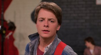 Movie still from “Back to the Future” (1985), directed by Robert Zemeckis – A young man with a red backpack is looking at the camera; Close Up shot, Low angle