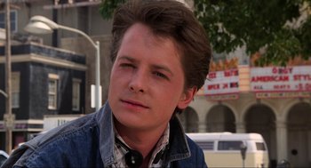 Movie still from “Back to the Future” (1985), directed by Robert Zemeckis – A young man is sitting down and looking into the distance; Close Up shot, Over the shoulder angle
