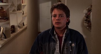 Movie still from “Back to the Future” (1985), directed by Robert Zemeckis – A man in a jean jacket is looking at the camera; Close Up shot, Over the shoulder angle