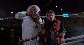 Movie still from “Back to the Future” (1985), directed by Robert Zemeckis – A man holding a fishing pole next to a man in a red vest; Medium shot, Over the shoulder angle