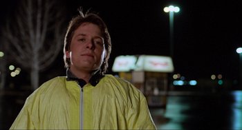 Movie still from “Back to the Future” (1985), directed by Robert Zemeckis – A man in a yellow jacket standing in front of a bus at night; Close Up shot, Low angle