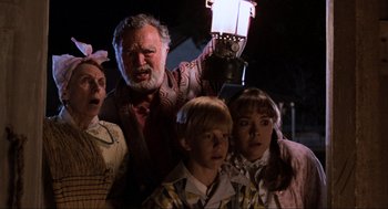 Movie still from “Back to the Future” (1985), directed by Robert Zemeckis – A group of people that are standing in front of a lamp; Medium shot, Low angle