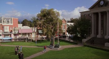 Movie still from “Back to the Future” (1985), directed by Robert Zemeckis – People walking in a park near a monument; Extreme Wide shot, High angle