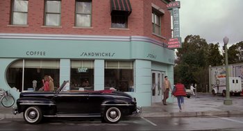Movie still from “Back to the Future” (1985), directed by Robert Zemeckis – An old car parked in front of a building; Wide shot, Over the shoulder angle