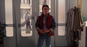 Movie still from “Back to the Future” (1985), directed by Robert Zemeckis – A man standing in front of an open door; Medium shot, Low angle