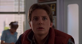 Movie still from “Back to the Future” (1985), directed by Robert Zemeckis – A young man in a red vest looking up at the sky; Close Up shot, Low angle