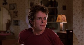 Movie still from “Back to the Future” (1985), directed by Robert Zemeckis – A young man sitting in front of a lamp; Close Up shot, Low angle