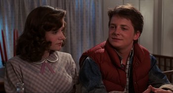 Movie still from “Back to the Future” (1985), directed by Robert Zemeckis – A woman and a man sitting next to each other in a room; Medium shot, Over the shoulder angle