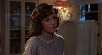 Movie still from “Back to the Future” (1985), directed by Robert Zemeckis – A young woman in a checkered shirt is looking to her left; Close Up shot, Over the shoulder angle