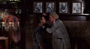 Movie still from “Back to the Future” (1985), directed by Robert Zemeckis – A man and a woman are fighting in front of pictures; Medium shot, Over the shoulder angle