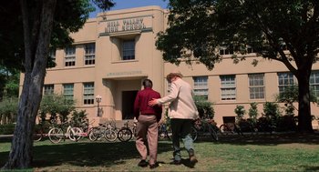 Movie still from “Back to the Future” (1985), directed by Robert Zemeckis – Two men standing in front of an old school building; Wide shot, Low angle