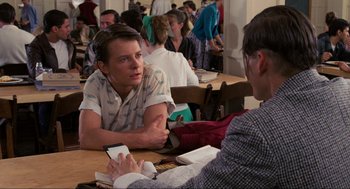 Movie still from “Back to the Future” (1985), directed by Robert Zemeckis – A man sitting at a table talking to another man; Medium shot, Over the shoulder angle