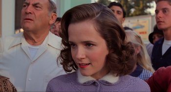 Movie still from “Back to the Future” (1985), directed by Robert Zemeckis – A young woman with brown curly hair and a purple sweater; Close Up shot, Over the shoulder angle