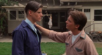 Movie still from “Back to the Future” (1985), directed by Robert Zemeckis – A young man adjusting a young man's collar; Medium shot, Over the shoulder angle