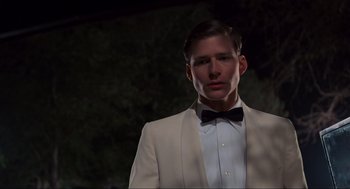 Movie still from “Back to the Future” (1985), directed by Robert Zemeckis – A man in a white suit with a bow tie; Close Up shot, Low angle
