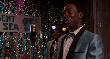 Movie still from “Back to the Future” (1985), directed by Robert Zemeckis – A couple of men standing next to each other in front of a microphone; Close Up shot, Over the shoulder angle