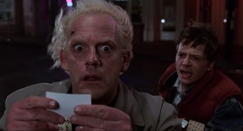 Movie still from “Back to the Future” (1985), directed by Robert Zemeckis – A man holding a piece of paper in front of another man; Close Up shot, Low angle