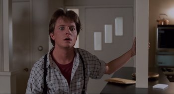 Movie still from “Back to the Future” (1985), directed by Robert Zemeckis – A man in a plaid shirt is sitting at a counter; Medium shot, Low angle