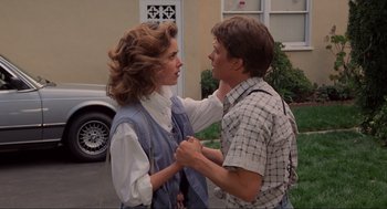 Movie still from “Back to the Future” (1985), directed by Robert Zemeckis – A man and a woman holding each other's hands outside; Medium shot, Over the shoulder angle